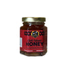 Jar of chili infused honey on a white background